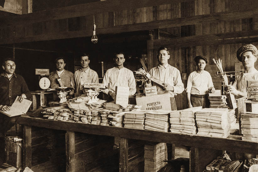 sepia photo of men working in macaroni factory